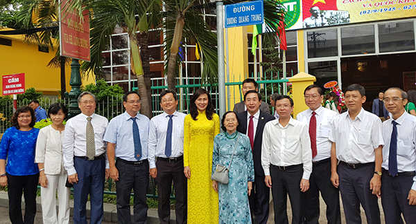 Phó chủ tịch UBND TP HCM Nguyễn Thị Thu (áo dài vàng) cùng gia đình viện sĩ Dương Quang Trung, các đại biểu dưới bảng tên đường mang tên thầy thuốc Dương Quang Trung. Ảnh: Lê Phương.